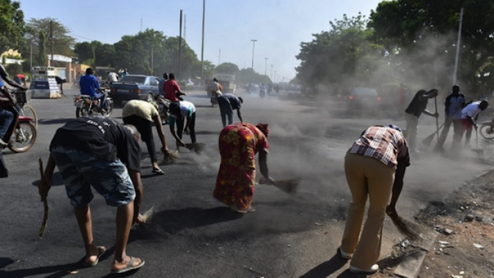 Mensen vegen de straten van Ouaga schoon on the day after (copyright Le Nouvel Observateur)